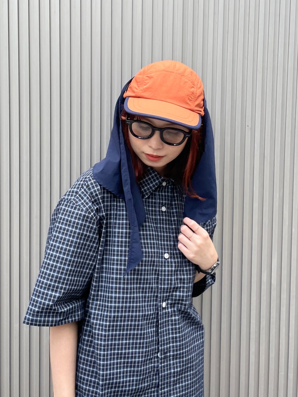 オレンジ系のキャップを着用したレディースの夏コーディネートの4枚目の写真