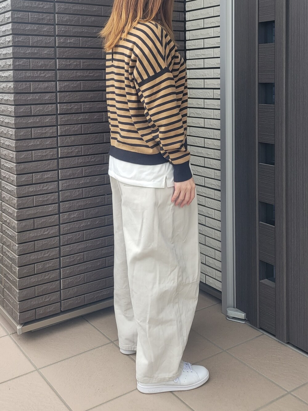 ベージュ系のその他パンツ、ゴールド系のスニーカー、ブラック系のニット/セーターを着用したレディースの春コーディネートの2枚目の写真