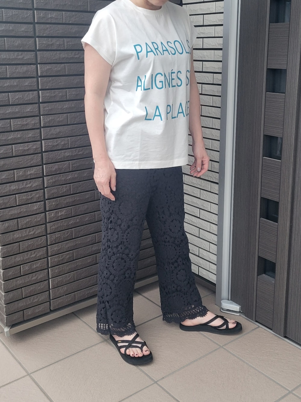 ホワイト系のTシャツ/カットソー、ブラック系のその他パンツ、ブラック系のサンダルを着用したレディースの夏コーディネートの2枚目の写真