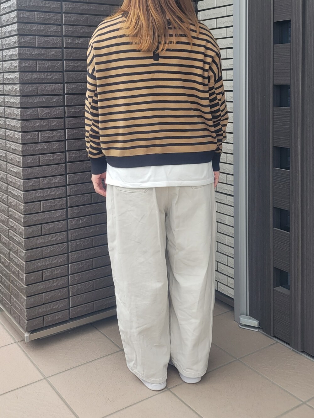 ベージュ系のその他パンツ、ゴールド系のスニーカー、ブラック系のニット/セーターを着用したレディースの春コーディネートの3枚目の写真