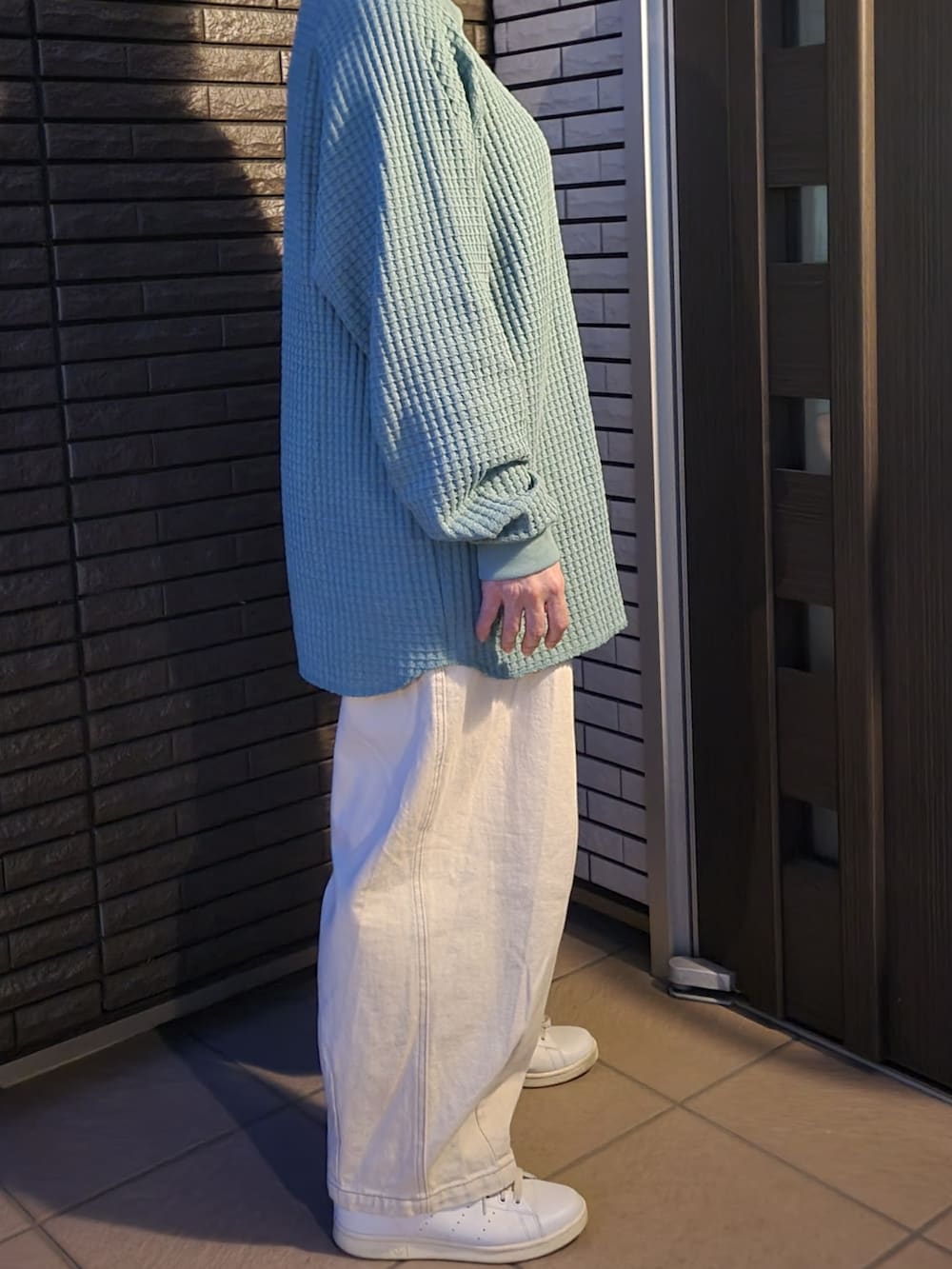 ベージュ系のデニムパンツ、ホワイト系のスニーカー、グリーン系のTシャツ/カットソーを着用したレディースの春コーディネートの4枚目の写真