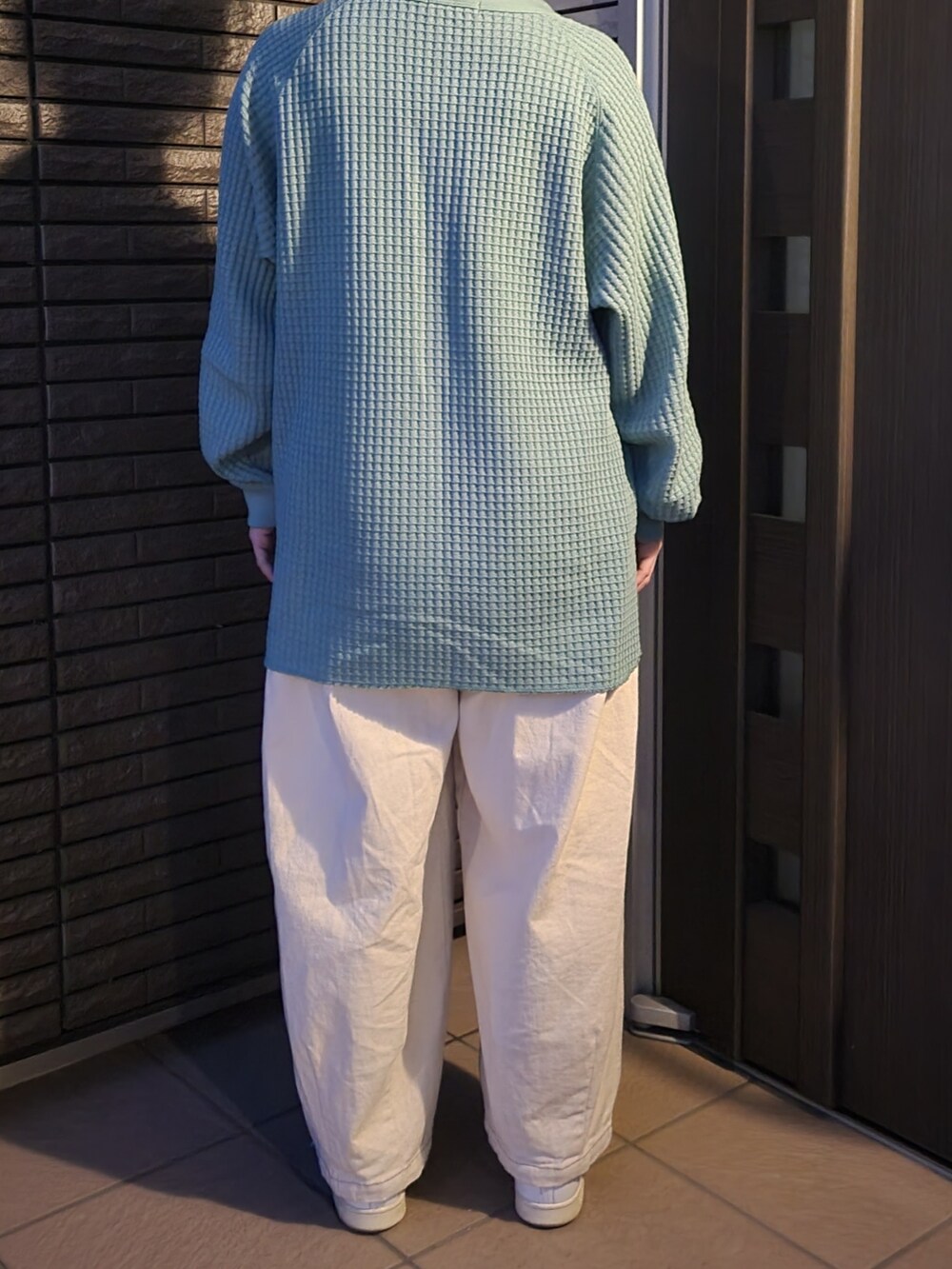 ベージュ系のデニムパンツ、ホワイト系のスニーカー、グリーン系のTシャツ/カットソーを着用したレディースの春コーディネートの2枚目の写真