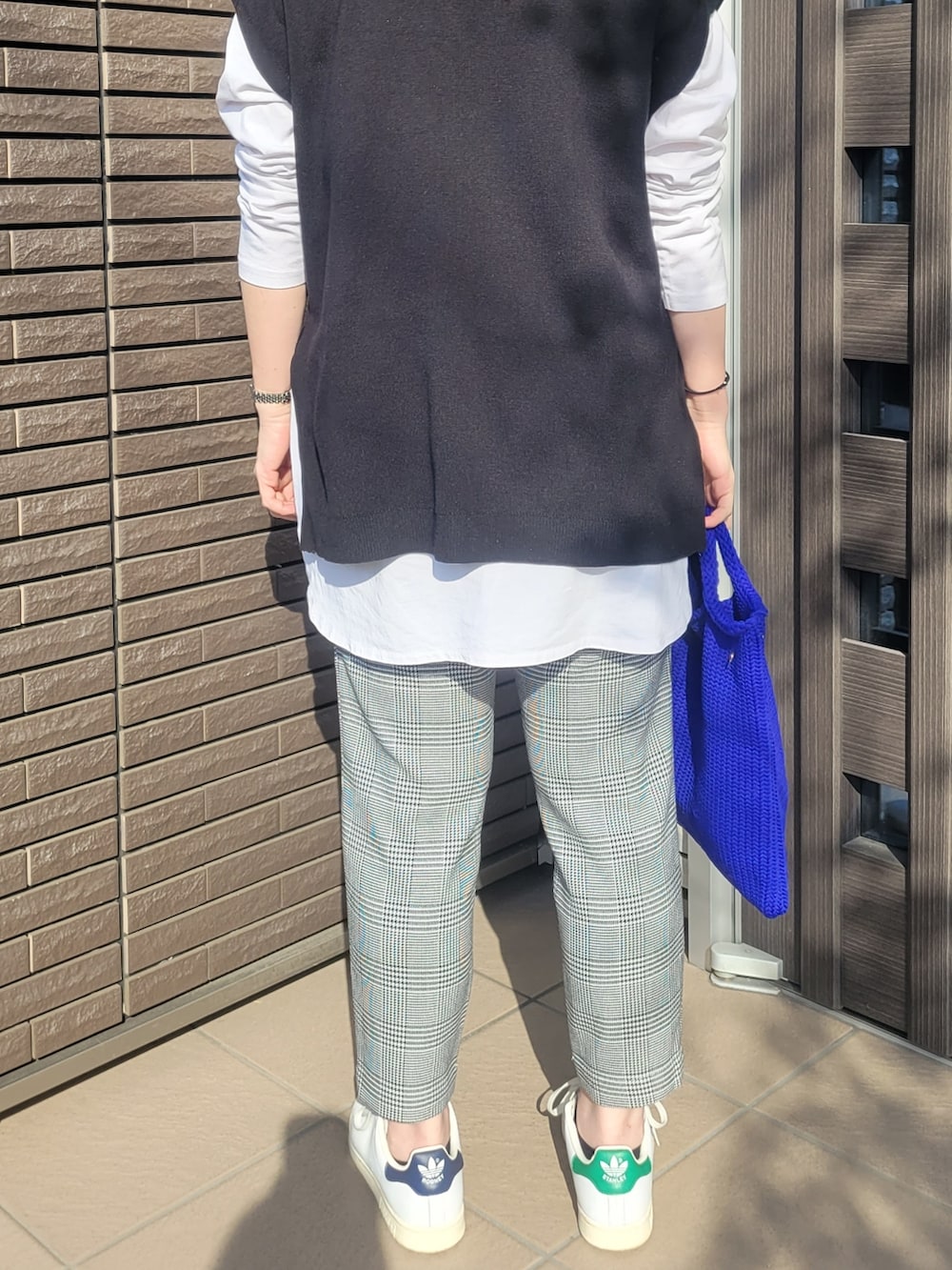 ブラック系のその他パンツ、ホワイト系のスニーカー、ブルー系のトートバッグを着用したレディースの春コーディネートの2枚目の写真