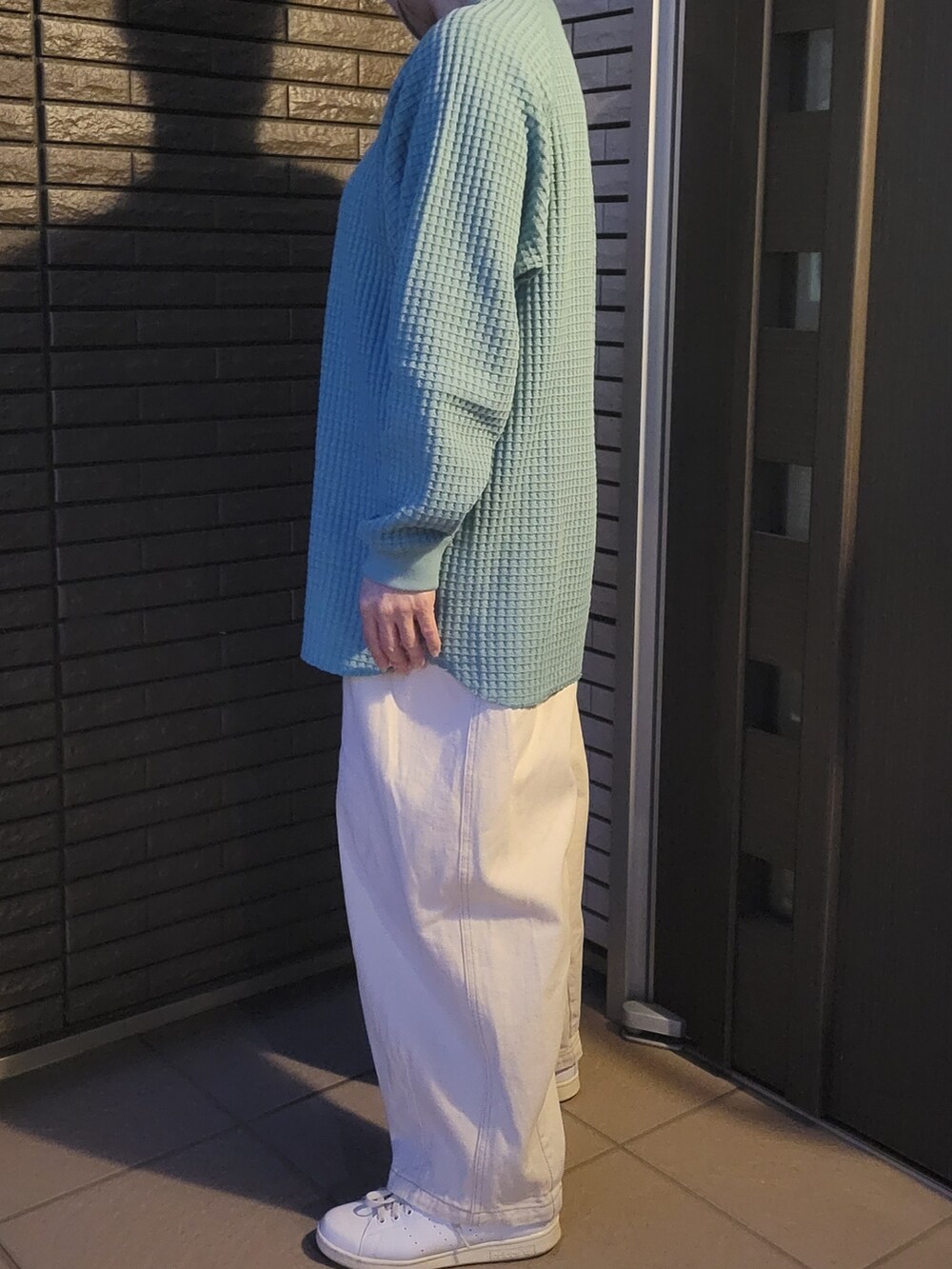 ベージュ系のデニムパンツ、ホワイト系のスニーカー、グリーン系のTシャツ/カットソーを着用したレディースの春コーディネートの3枚目の写真