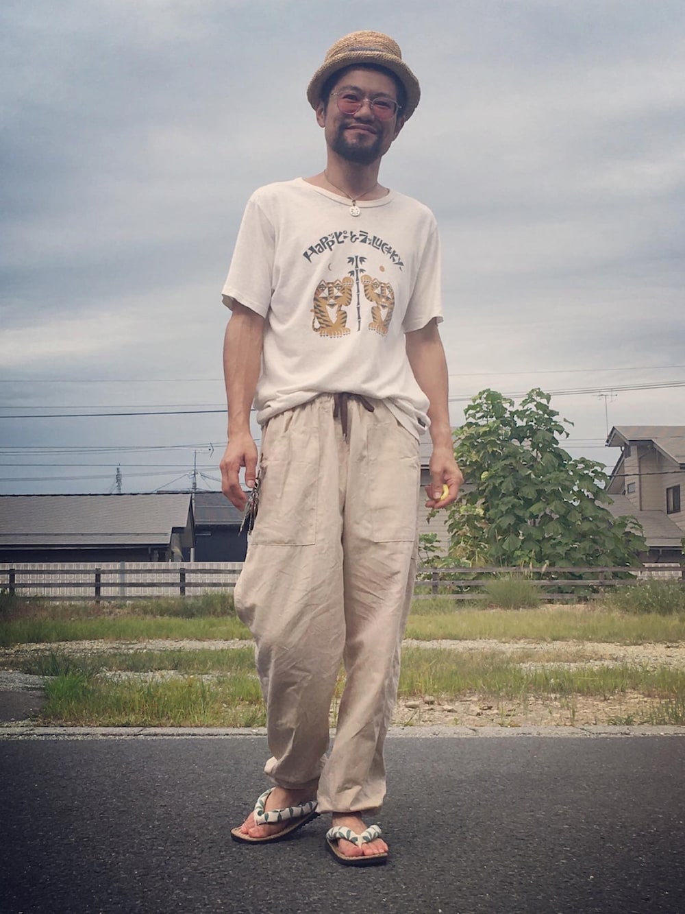 ホワイト系のTシャツ/カットソー、ベージュ系のパンツ、ベージュ系のサンダルを着用したメンズの秋コーディネートの4枚目の写真