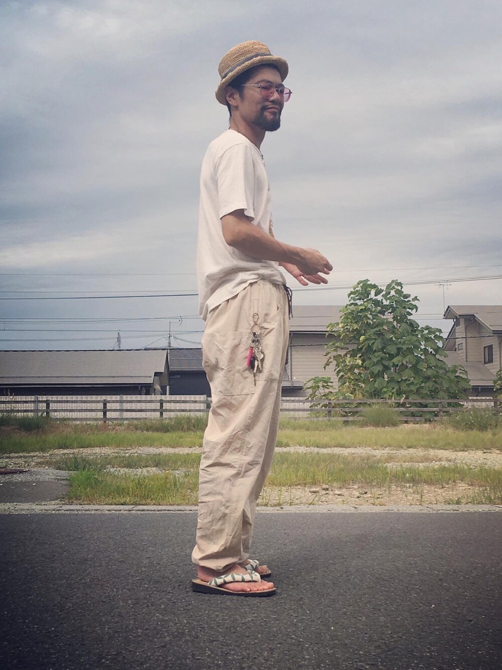 ホワイト系のTシャツ/カットソー、ベージュ系のパンツ、ベージュ系のサンダルを着用したメンズの秋コーディネートの2枚目の写真