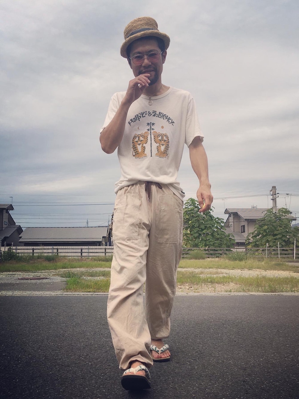 ホワイト系のTシャツ/カットソー、ベージュ系のパンツ、ベージュ系のサンダルを着用したメンズの秋コーディネートの5枚目の写真