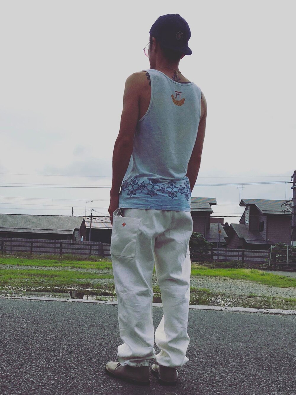 ホワイト系のパンツ、ブルー系のトップスを着用したメンズの夏コーディネートの4枚目の写真