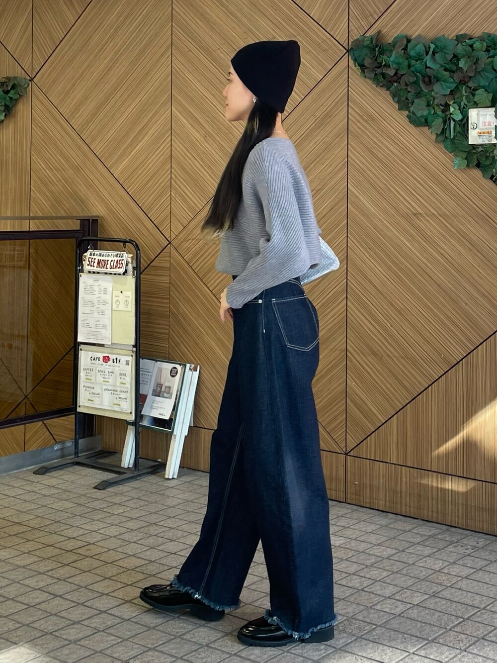 ブルー系のデニムパンツ、ブラック系のローファー、グレー系のニット/セーターを着用したレディースの冬コーディネートの3枚目の写真