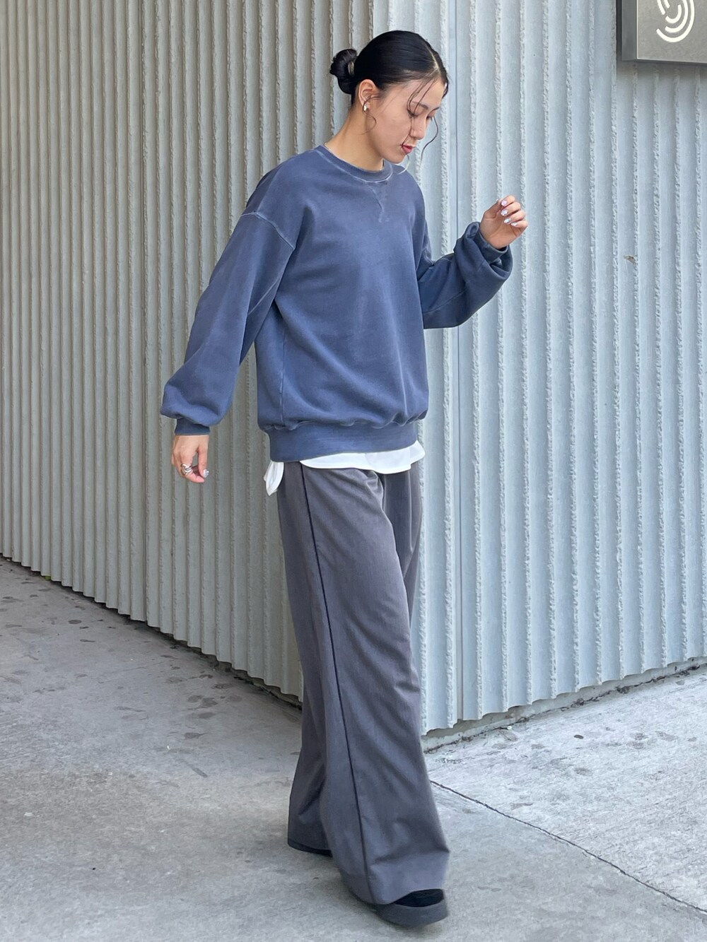 ブルー系のスウェット、グレー系のパンツ、ブラック系のモカシン/デッキシューズを着用したレディースの秋コーディネートの2枚目の写真