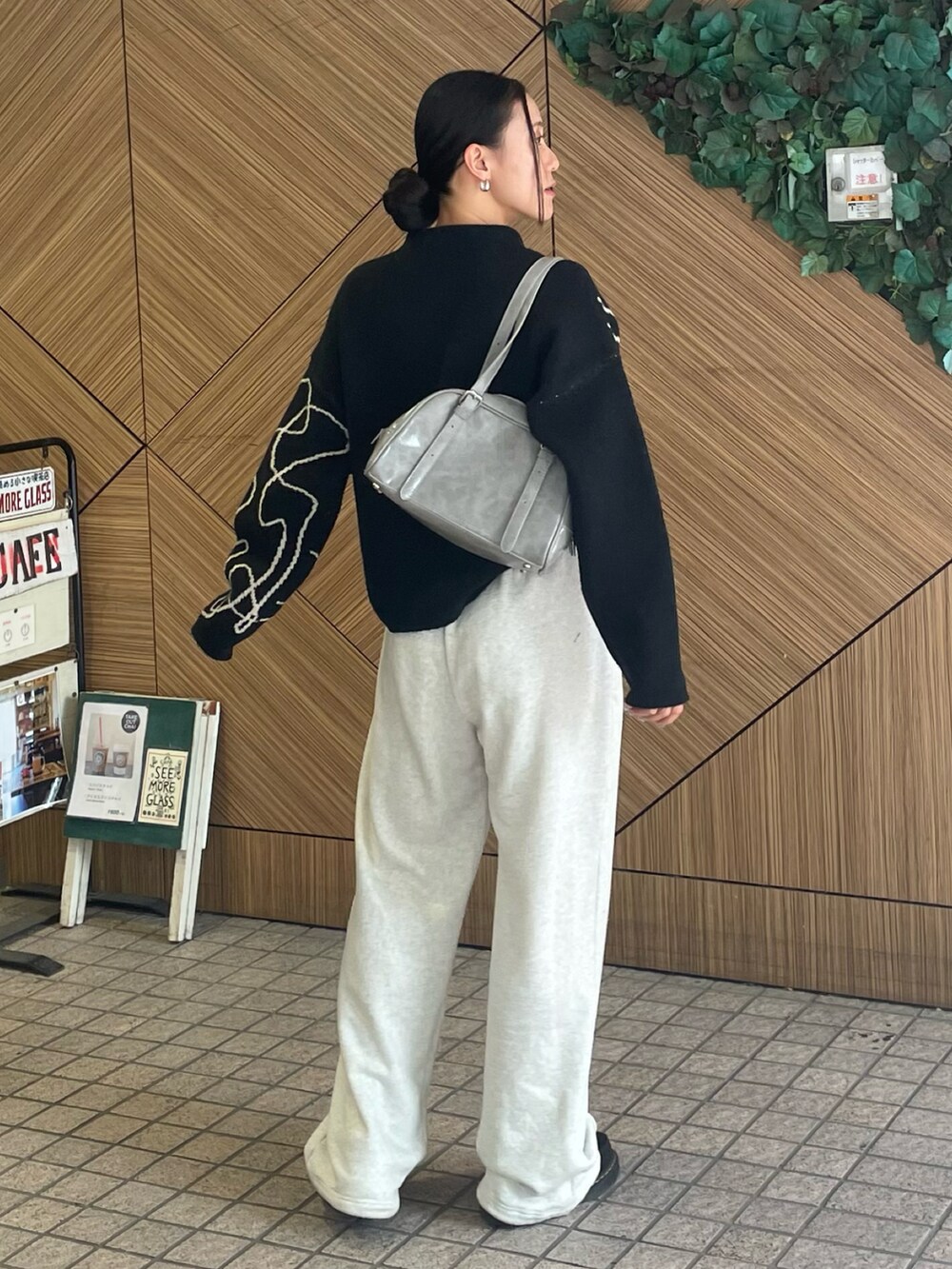 グレー系のボストンバッグ、ホワイト系のスウェットパンツ、ブラック系のニット/セーターを着用したレディースの秋コーディネートの2枚目の写真