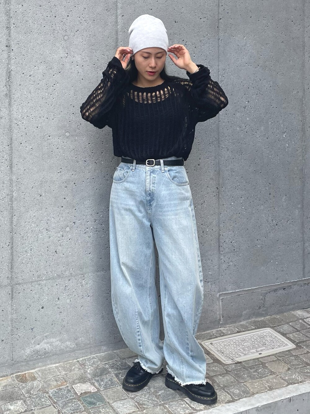 ブラック系のニット/セーター、ブルー系のデニムパンツ、グレー系のニットキャップ/ビーニーを着用したレディースの夏コーディネートの2枚目の写真