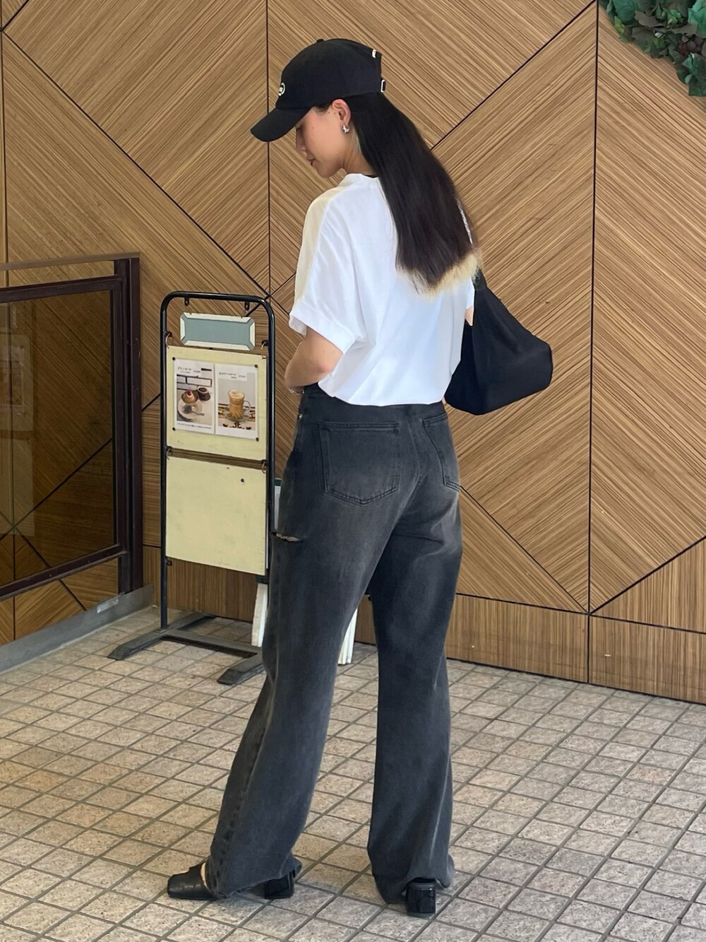 ホワイト系のTシャツ/カットソー、ブラック系のデニムパンツ、ブラック系のサンダルを着用したレディースの夏コーディネートの2枚目の写真