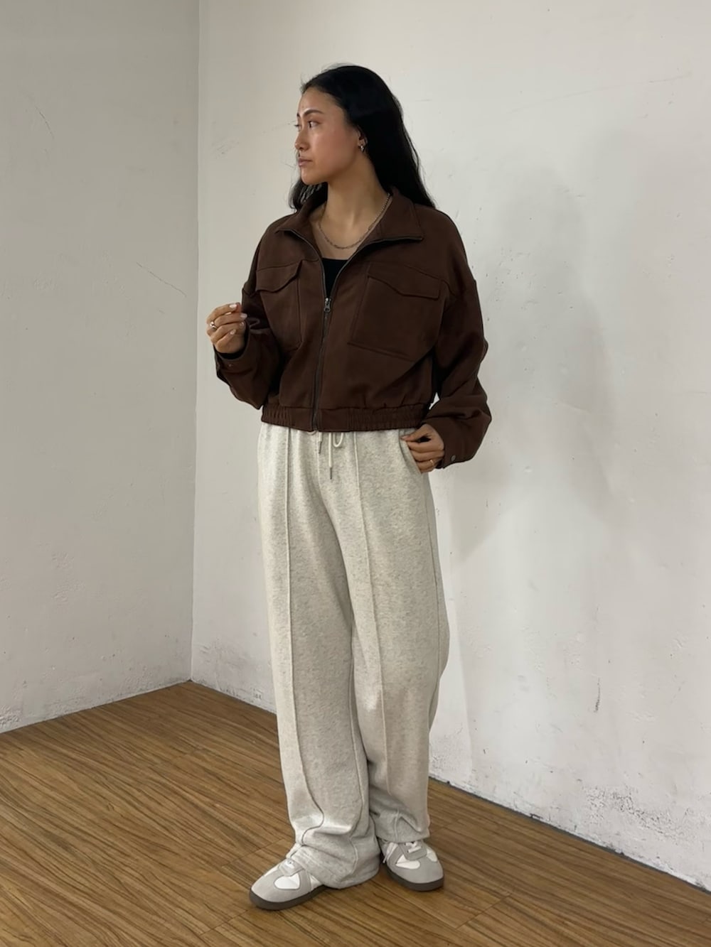 ブラウン系のブルゾン、ホワイト系のスウェットパンツを着用したレディースの春コーディネートの2枚目の写真