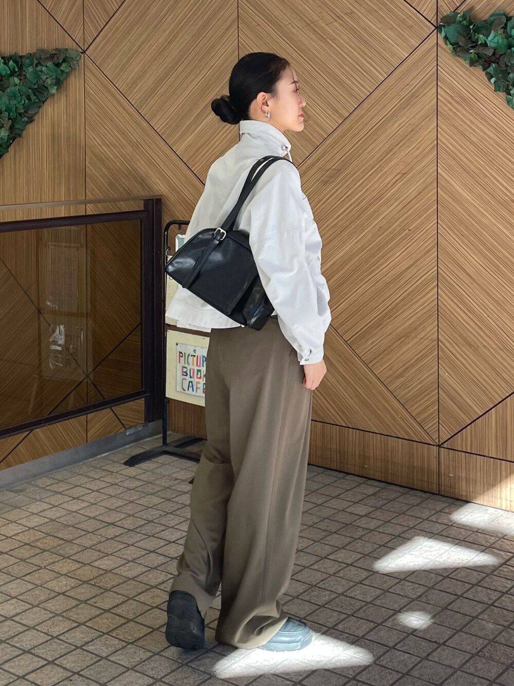 グレー系のブルゾン、グリーン系のその他パンツ、ブラック系のボストンバッグを着用したレディースの冬コーディネートの2枚目の写真