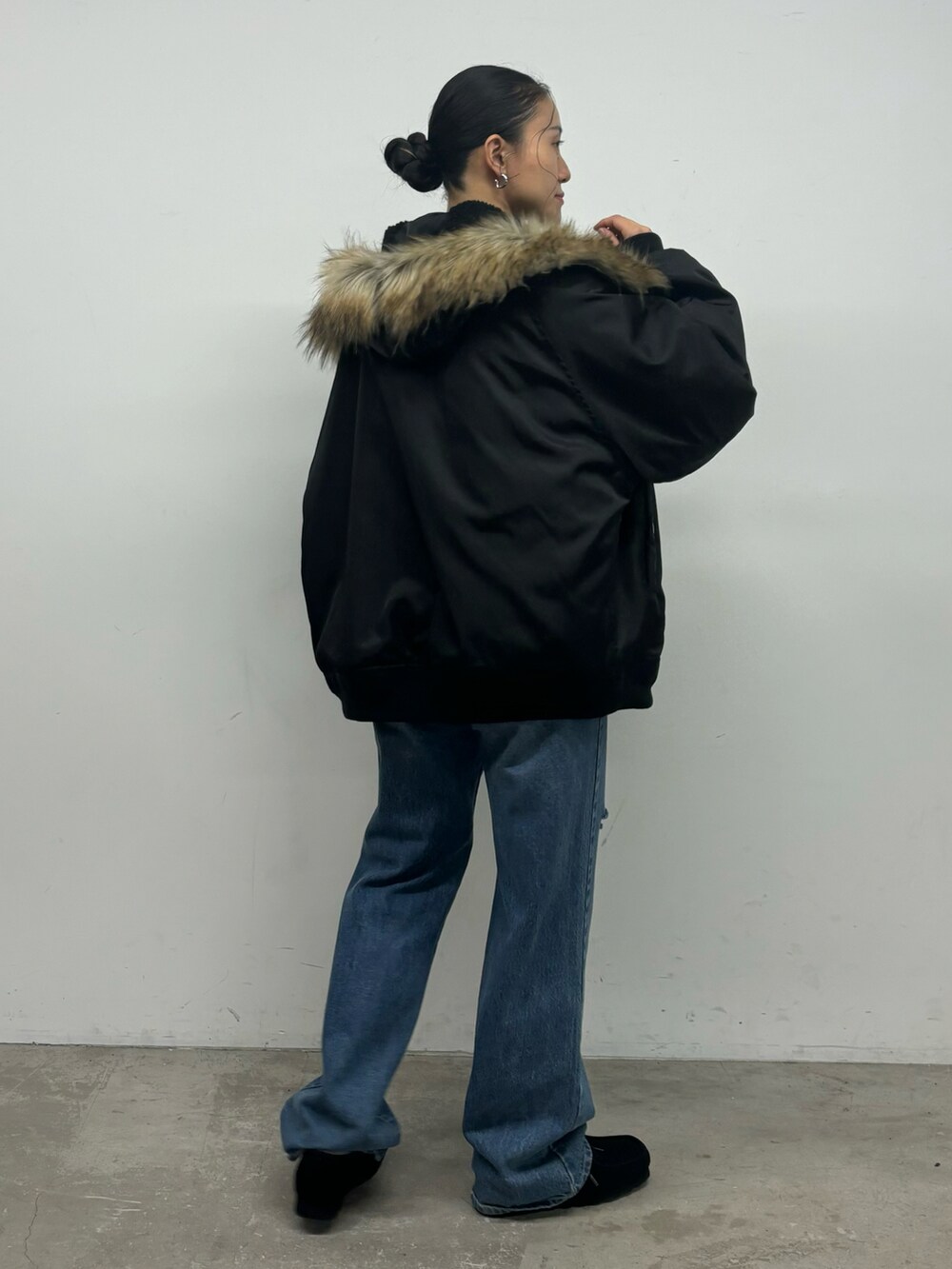 ブルー系のデニムパンツ、ブラック系のその他アウターを着用したレディースの秋コーディネートの2枚目の写真