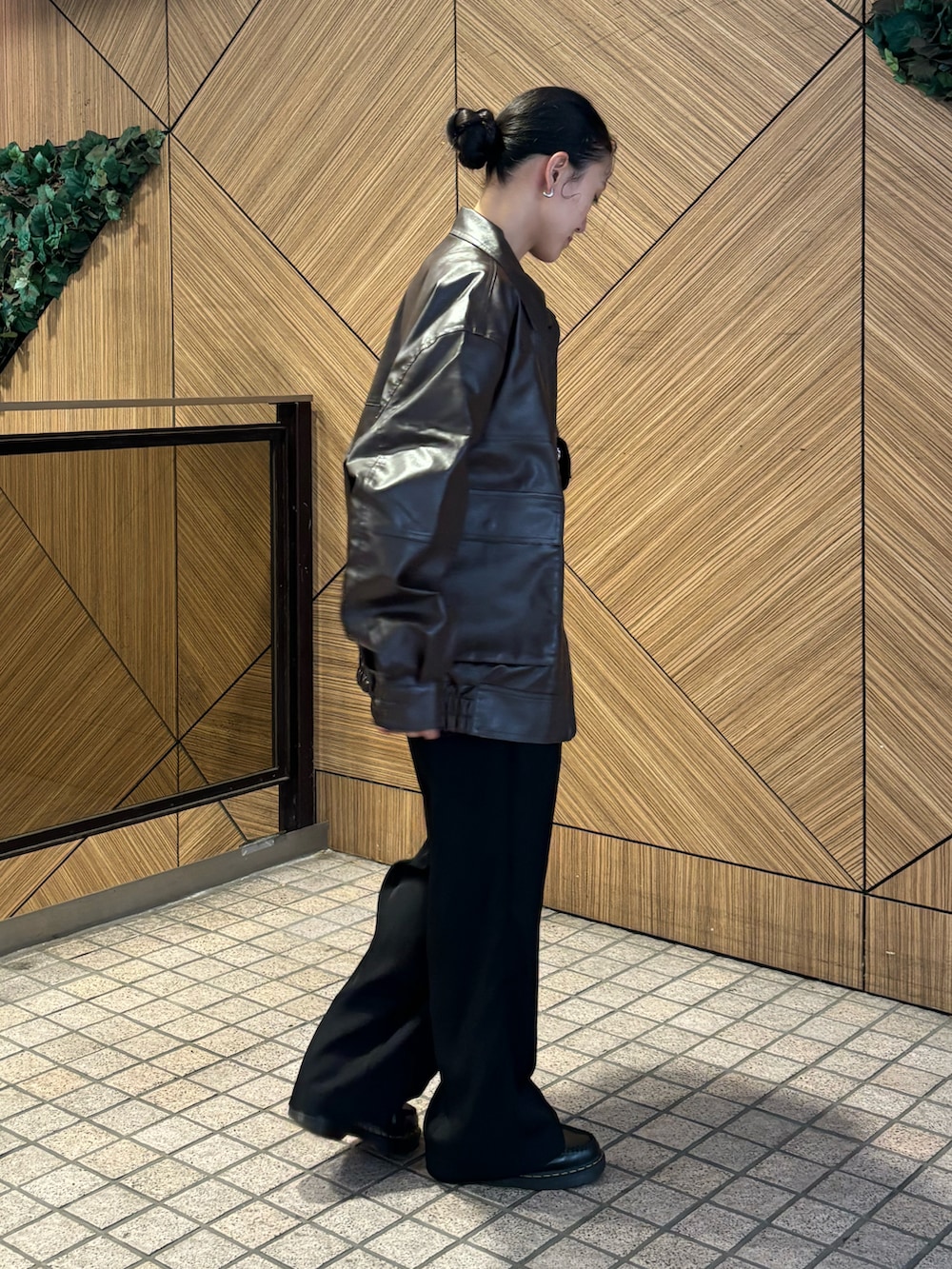 ブラウン系のブルゾン、ブラック系のスラックスを着用したレディースの秋コーディネートの2枚目の写真