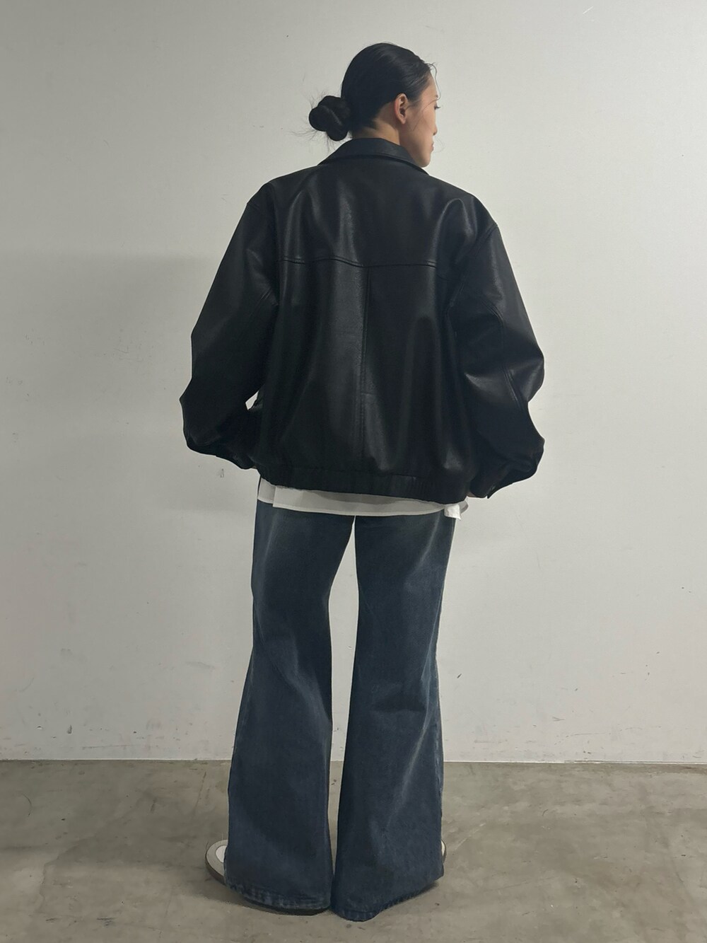 ブルー系のデニムパンツ、ホワイト系のシャツ/ブラウス、ブラック系のブルゾンを着用したレディースの冬コーディネートの2枚目の写真