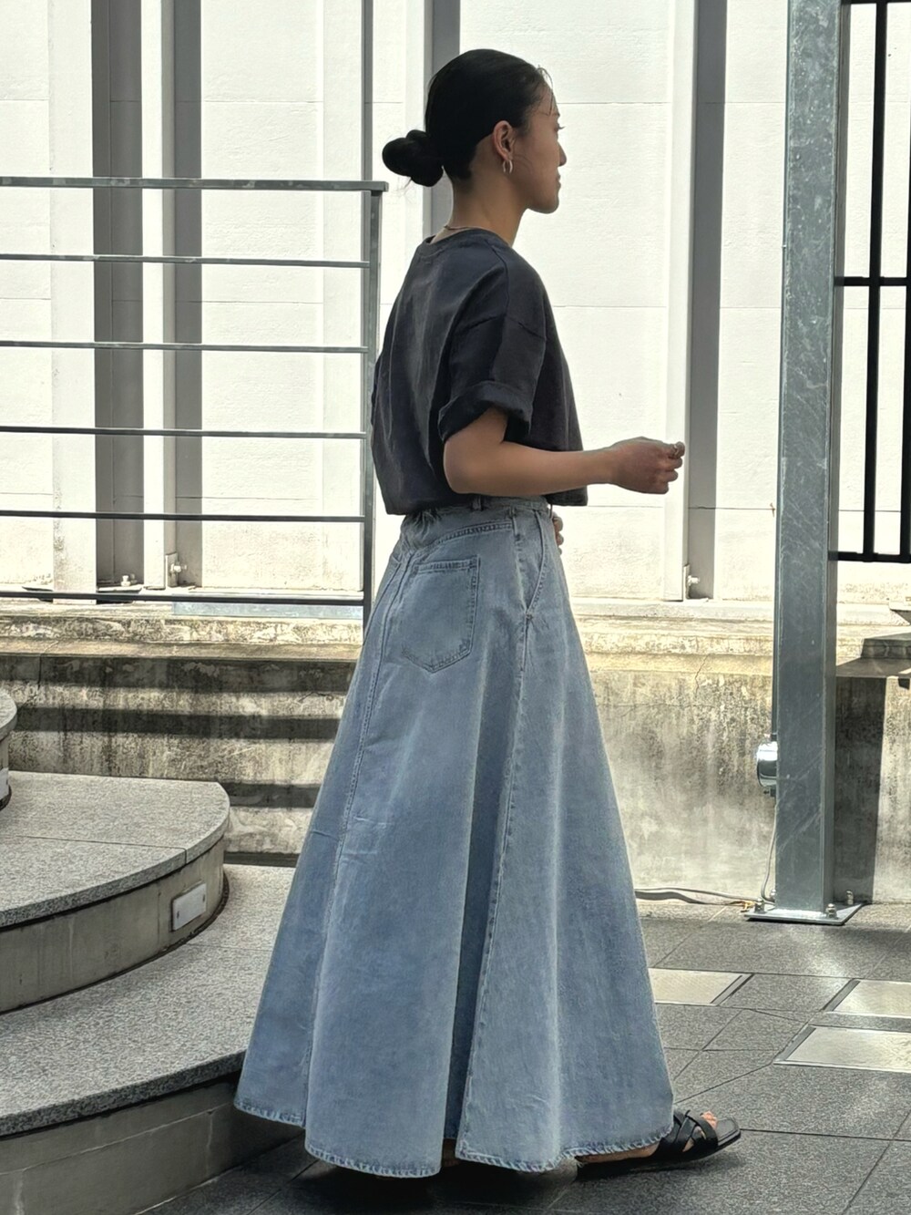 グレー系のTシャツ/カットソー、ブルー系のデニムスカートを着用したレディースの春コーディネートの2枚目の写真