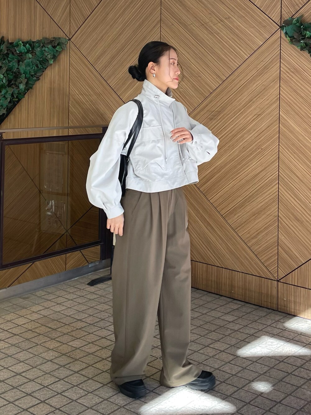 グレー系のブルゾン、グリーン系のその他パンツ、ブラック系のボストンバッグを着用したレディースの冬コーディネートの3枚目の写真