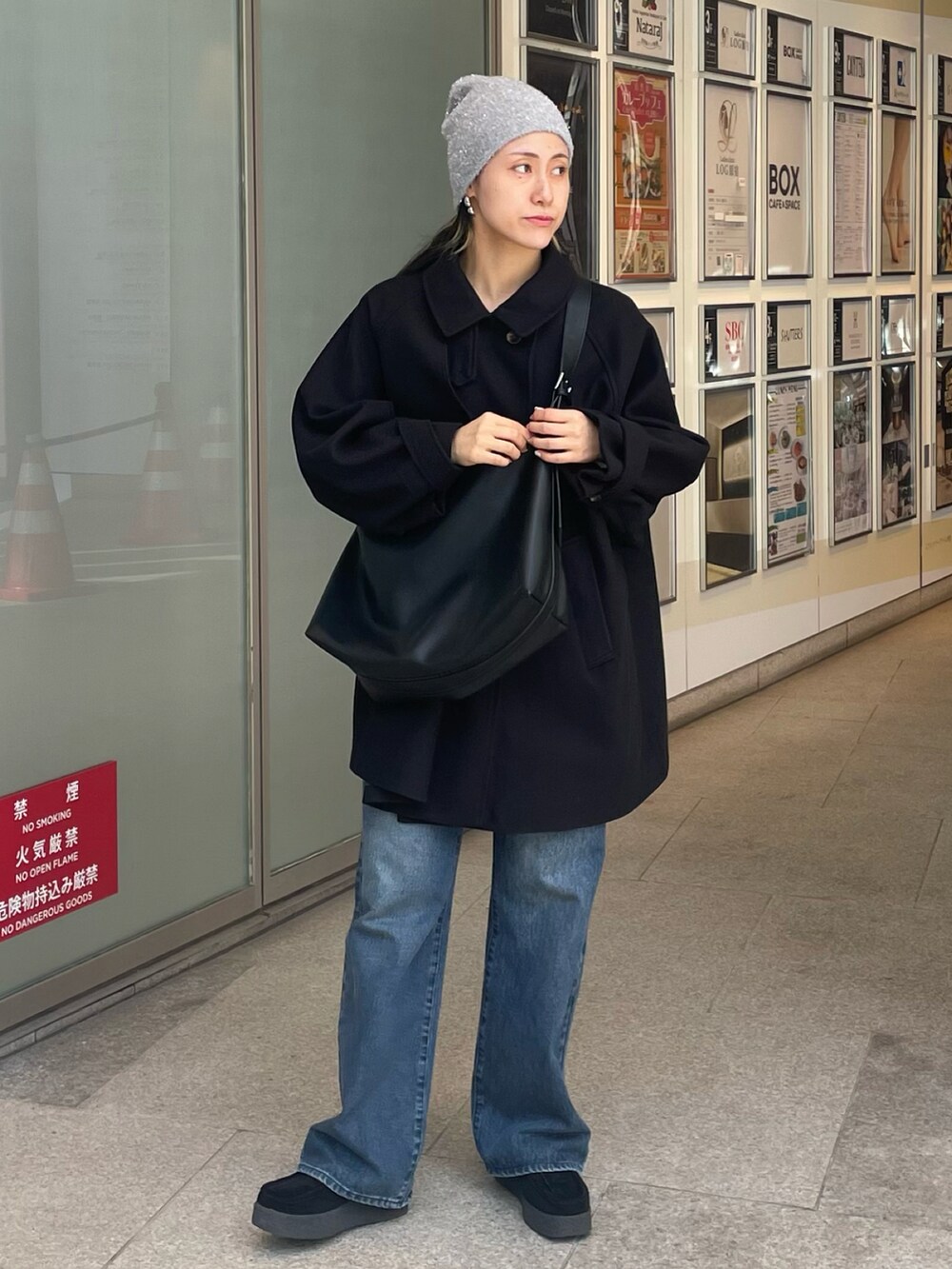 ブラック系のショルダーバッグ、ブルー系のデニムパンツ、ブラック系のモカシン/デッキシューズを着用したレディースの秋コーディネートの2枚目の写真