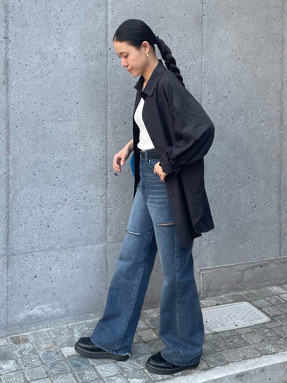 ブルー系のデニムパンツ、ブルー系のトートバッグ、ブラック系のラッシュガードを着用したレディースの春コーディネートの2枚目の写真