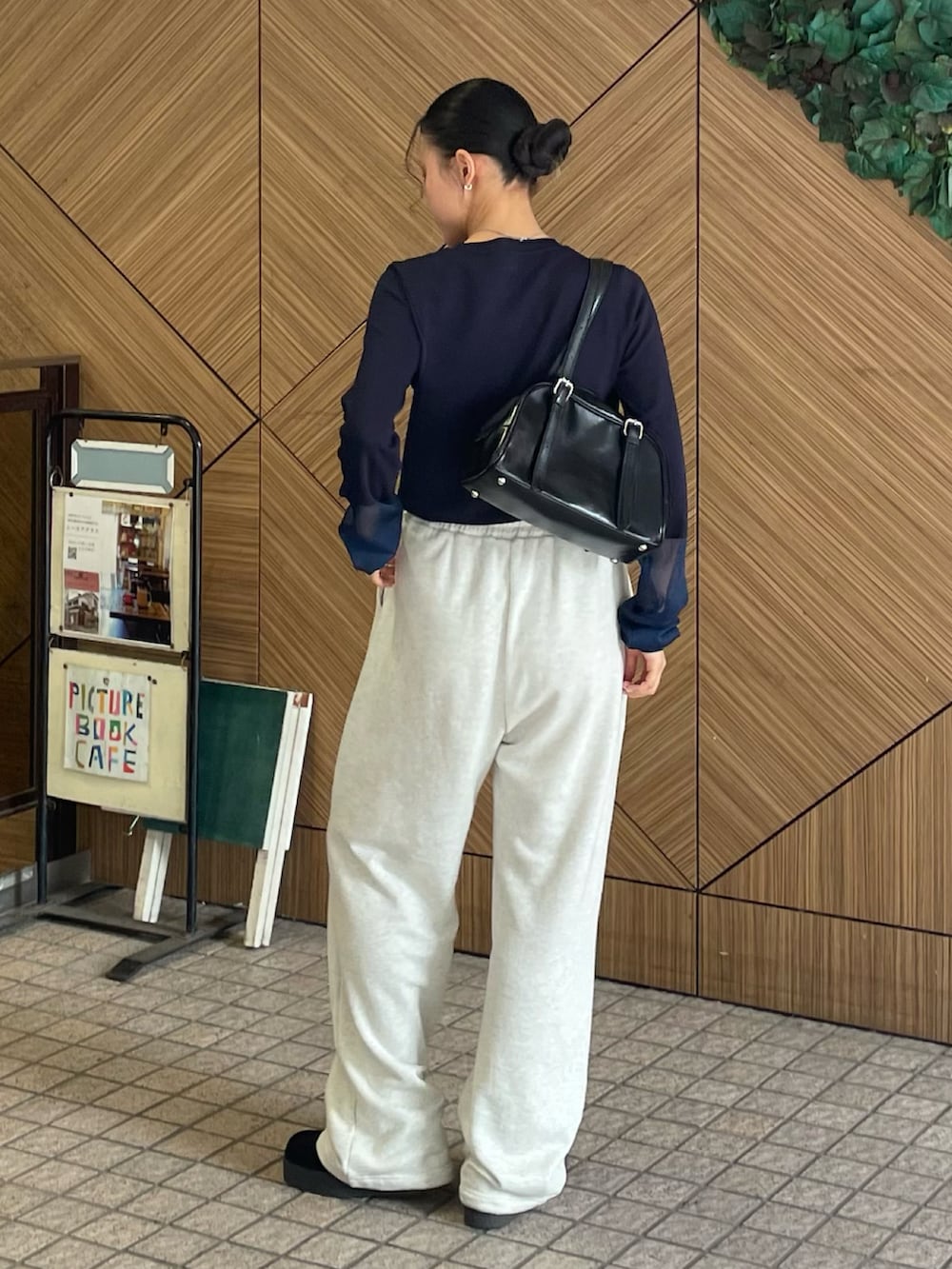 ブラック系のボストンバッグ、ホワイト系のスウェットパンツ、ブルー系のニット/セーターを着用したレディースの秋コーディネートの2枚目の写真