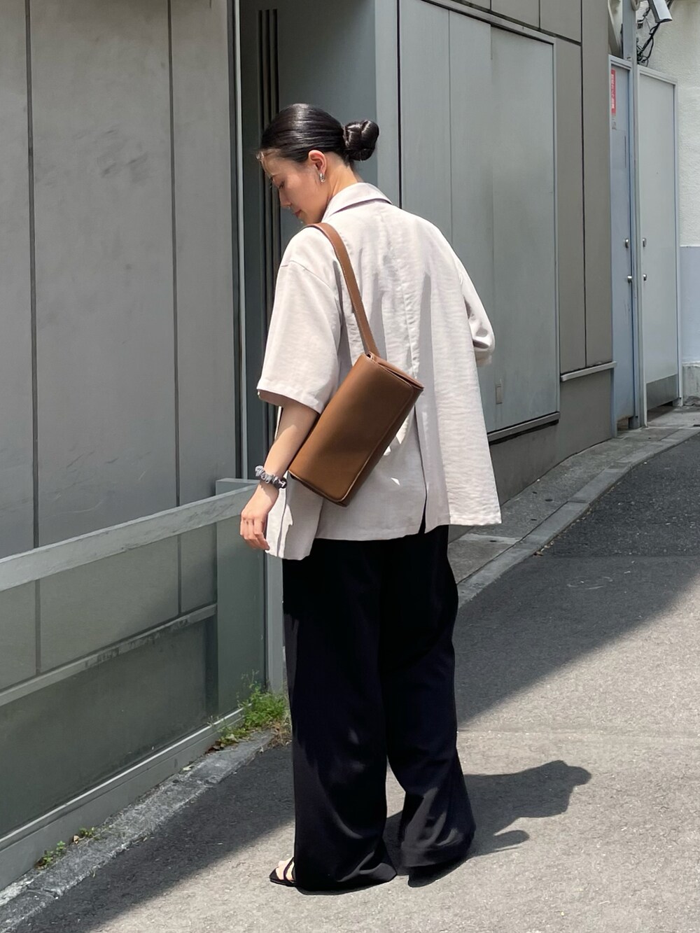 ブラウン系のボディバッグ/ウエストポーチ、ベージュ系のテーラードジャケット、ブラック系のパンツを着用したレディースの春コーディネートの2枚目の写真