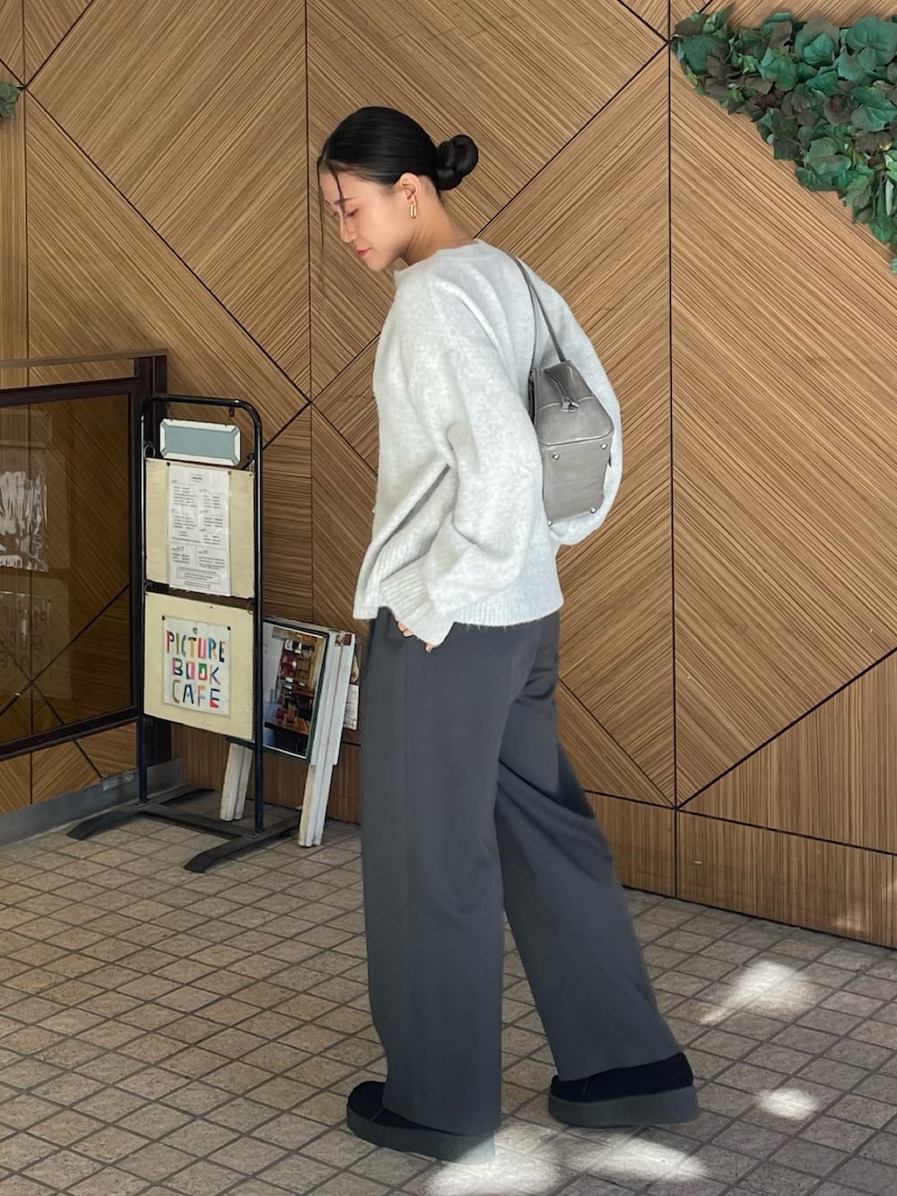 グレー系のニット/セーター、グレー系のボストンバッグ、グレー系のスラックスを着用したレディースの冬コーディネートの3枚目の写真