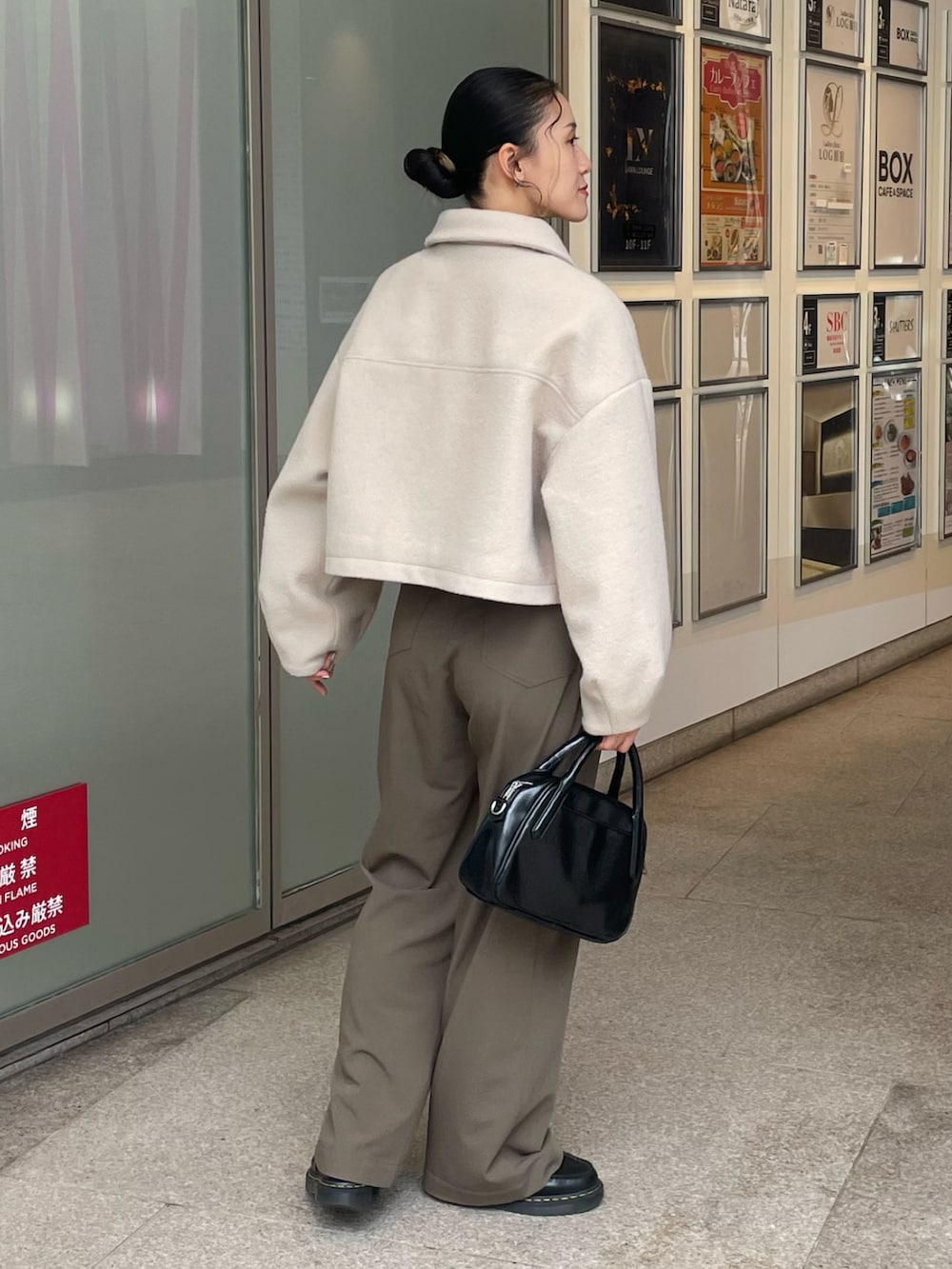 ベージュ系のブルゾン、ブラック系のボストンバッグを着用したレディースの秋コーディネートの2枚目の写真