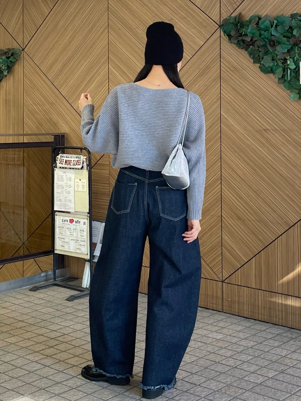 ブルー系のデニムパンツ、ブラック系のローファー、グレー系のニット/セーターを着用したレディースの冬コーディネートの2枚目の写真