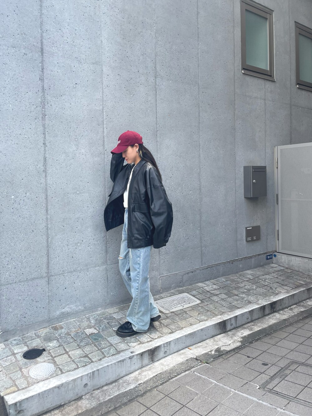 ホワイト系のスラックス、ブルー系のベスト、ブラック系のボストンバッグを着用したレディースの夏コーディネートの2枚目の写真