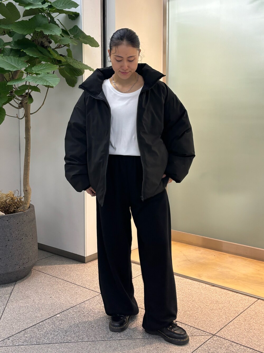 ブラック系のスラックスを着用したレディースの秋コーディネートの3枚目の写真