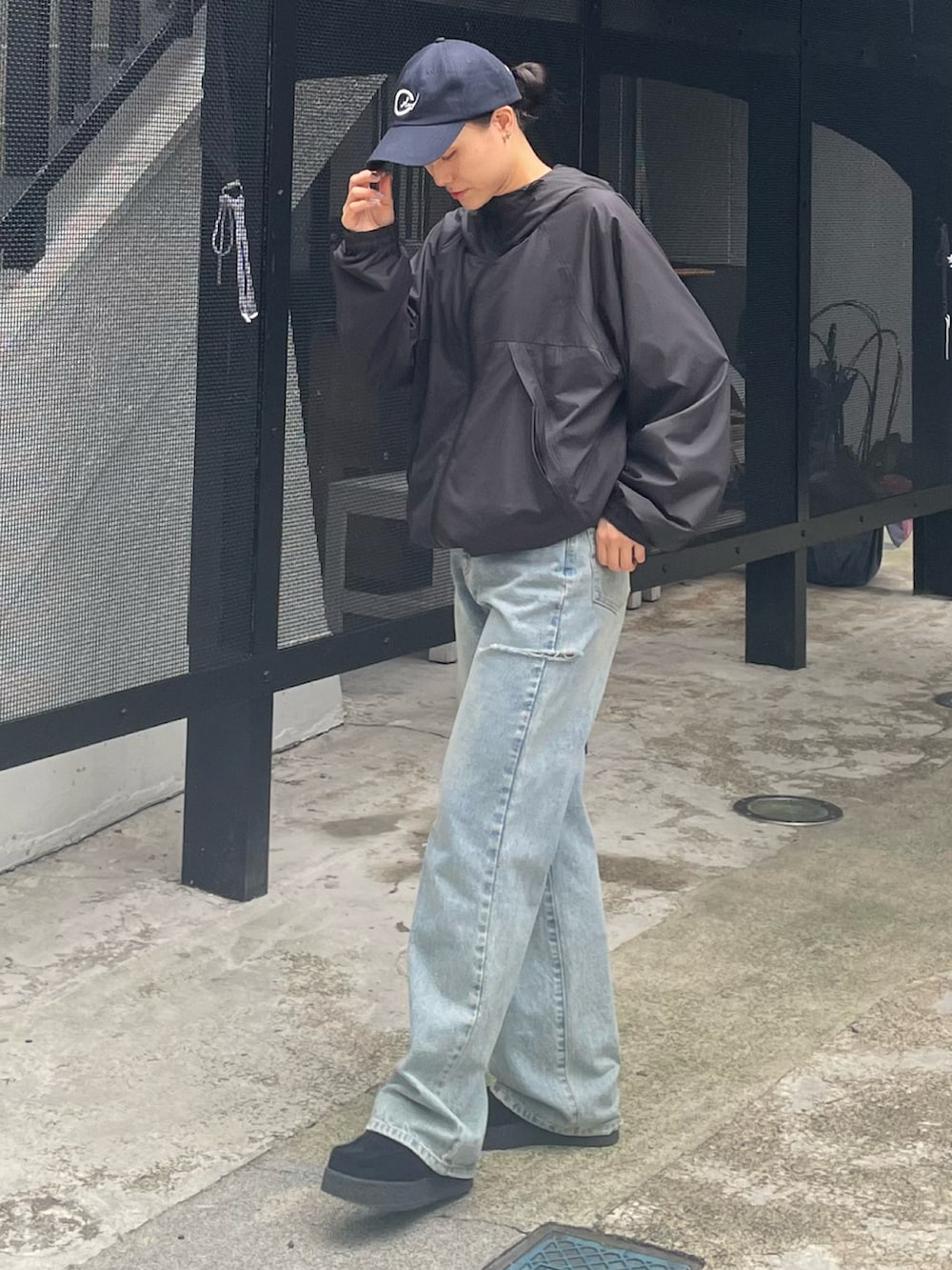 ブラック系のマウンテンパーカー、ブルー系のデニムパンツ、ブラック系のモカシン/デッキシューズを着用したレディースの秋コーディネートの2枚目の写真