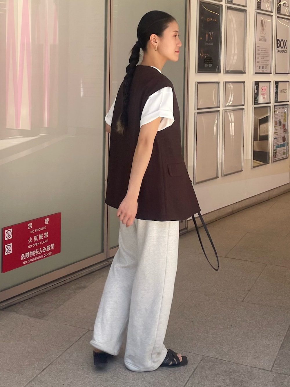 ホワイト系のスウェットパンツ、ブラック系のサンダル、ホワイト系のTシャツ/カットソーを着用したレディースの春コーディネートの2枚目の写真