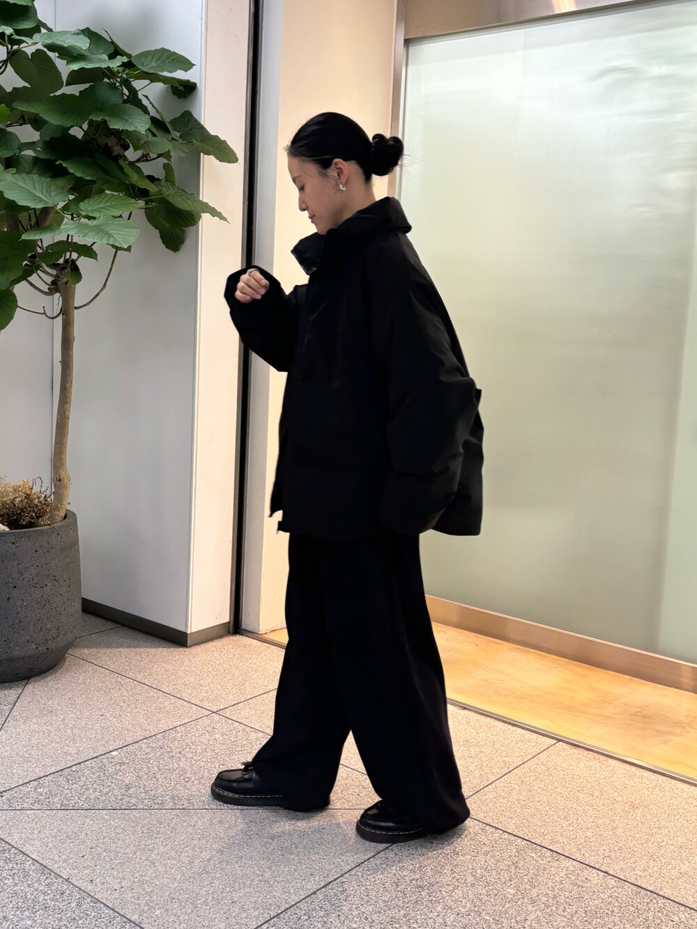 ブラック系のスラックスを着用したレディースの秋コーディネートの2枚目の写真