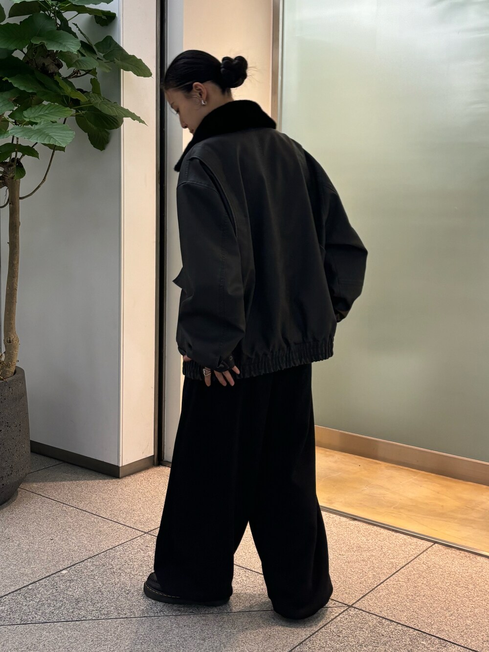 ブラック系のスラックスを着用したレディースの秋コーディネートの2枚目の写真