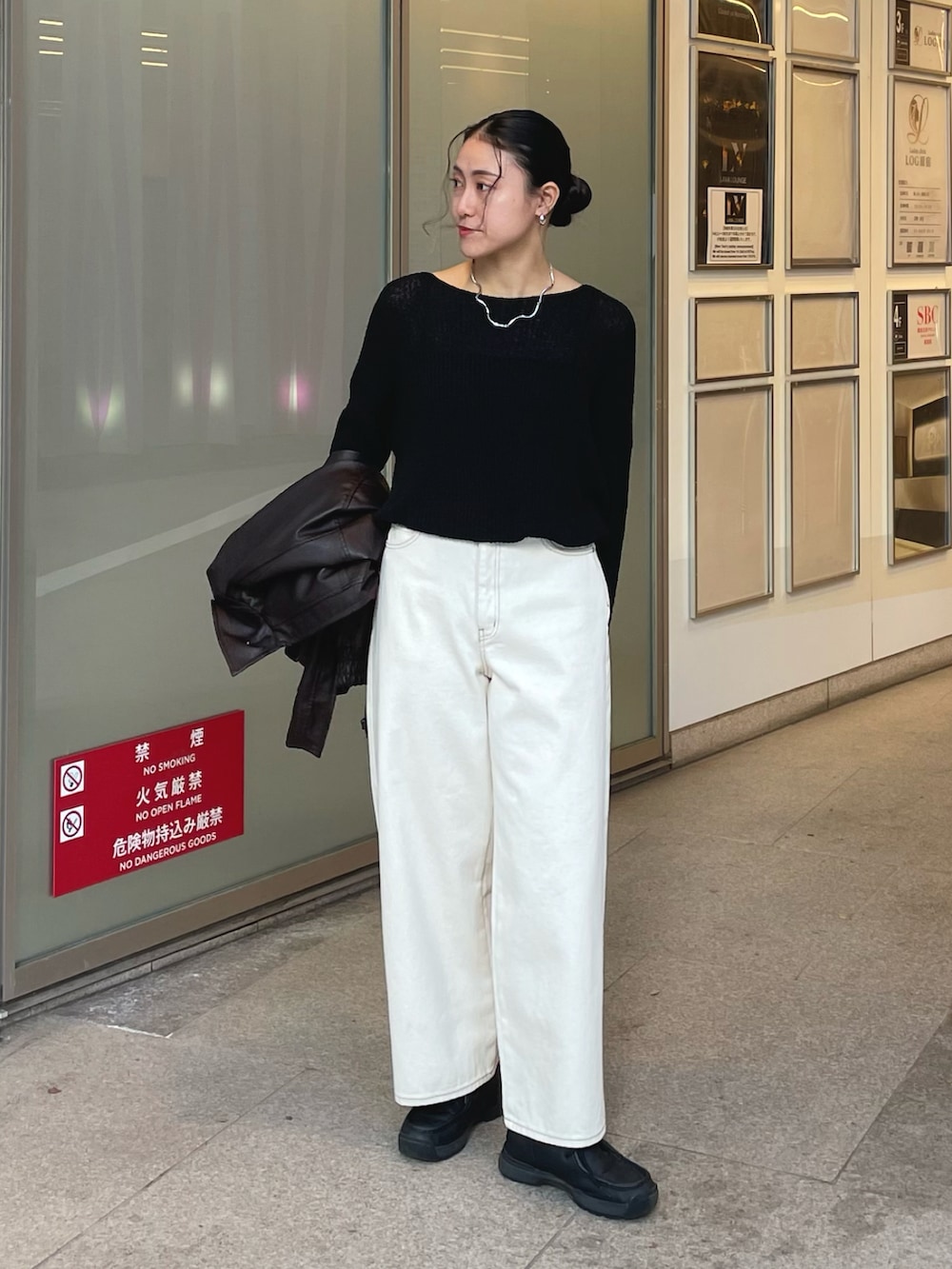 ブラック系のニット/セーター、ホワイト系のデニムパンツ、ブラウン系のブルゾンを着用したレディースの冬コーディネートの3枚目の写真