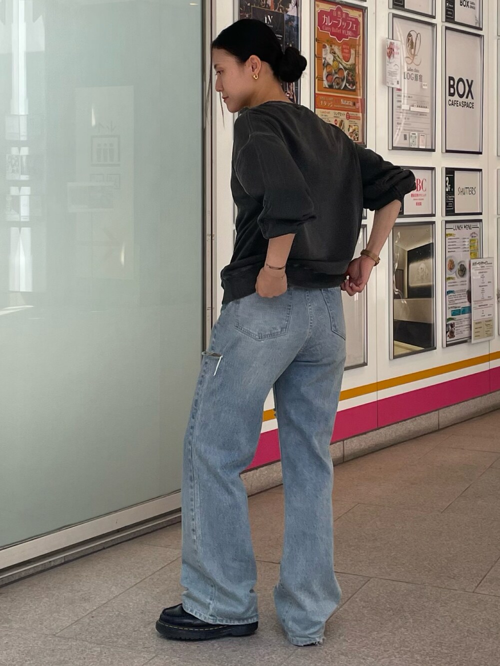 グレー系のスウェット、ブルー系のデニムパンツを着用したレディースの秋コーディネートの2枚目の写真