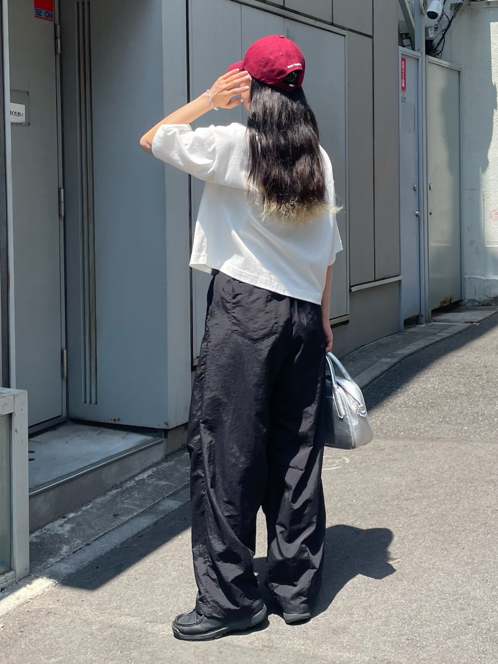 ホワイト系のTシャツ/カットソー、ブラック系のその他パンツ、シルバー系のボストンバッグを着用したレディースの夏コーディネートの3枚目の写真