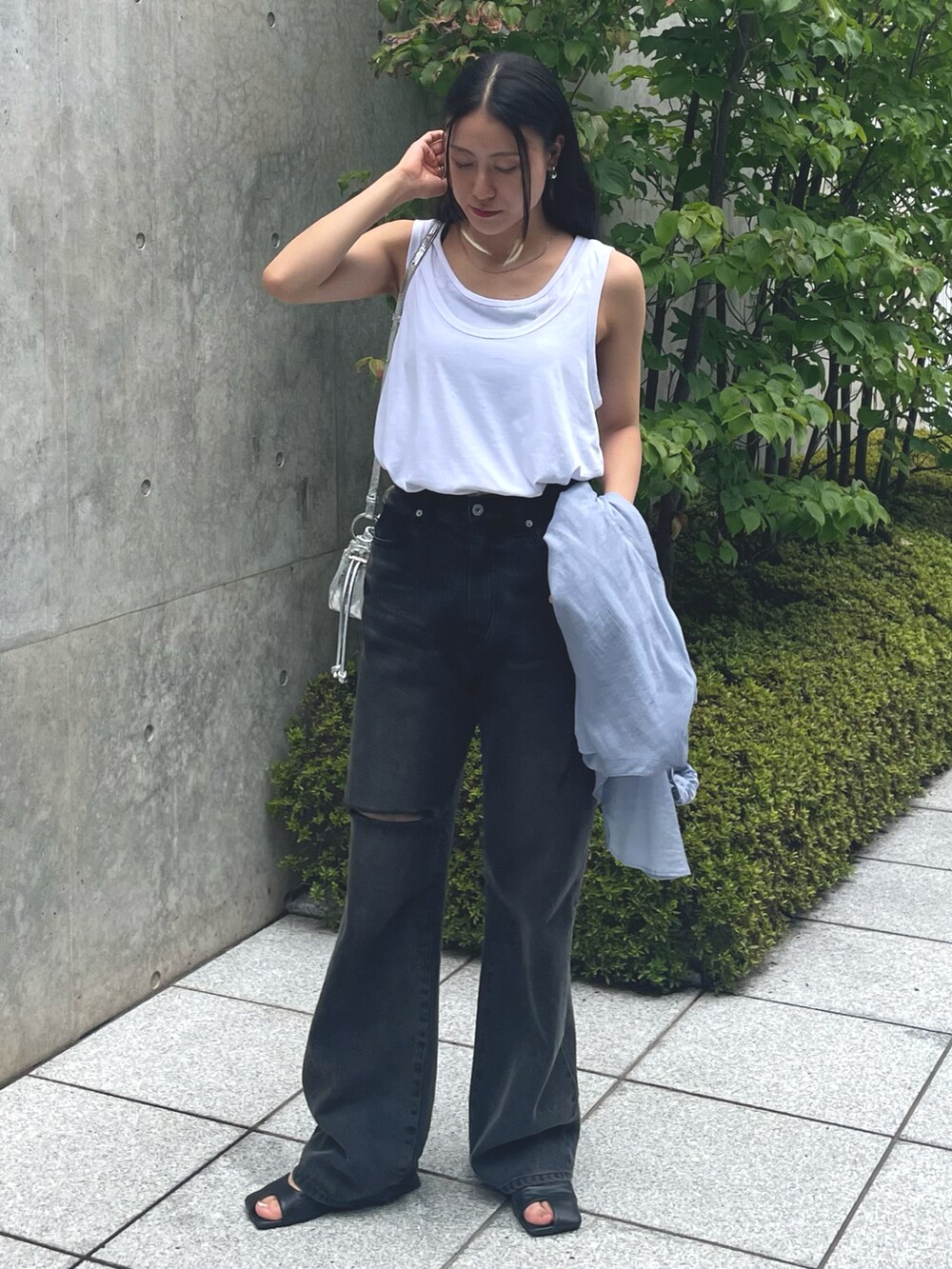 ブラック系のデニムパンツ、ブラック系のサンダル、ブルー系のシャツ/ブラウスを着用したレディースの夏コーディネートの2枚目の写真