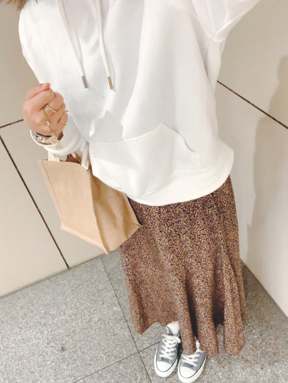 グレー系のスニーカー、その他のスカート、ホワイト系のパーカーを着用したレディースの春コーディネートの3枚目の写真