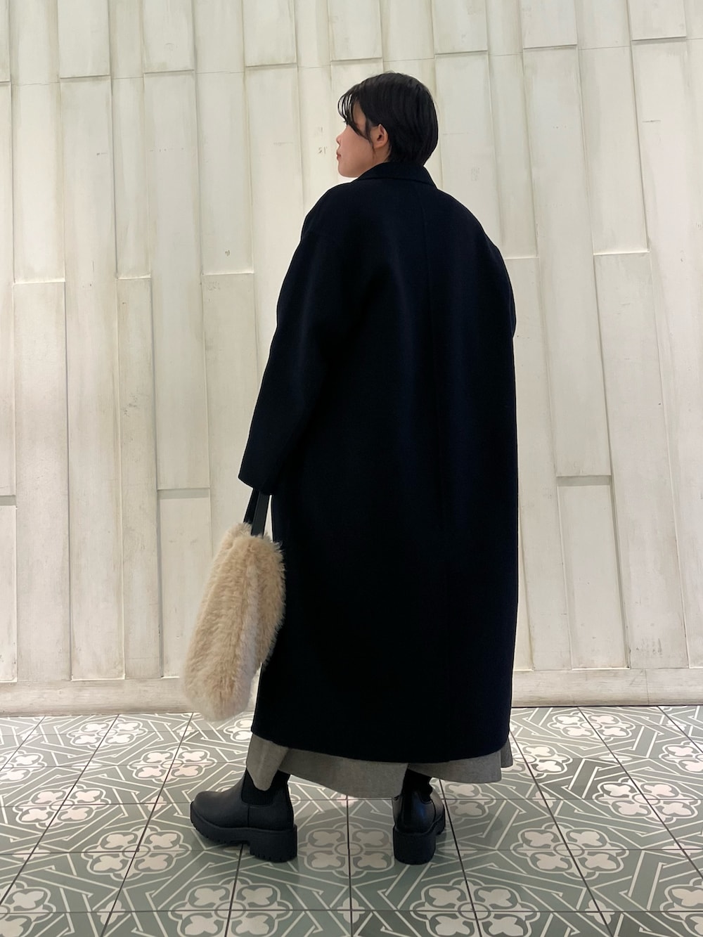 ブルー系のその他アウター、ホワイト系のニット/セーター、グレー系のワンピースを着用したレディースの冬コーディネートの2枚目の写真