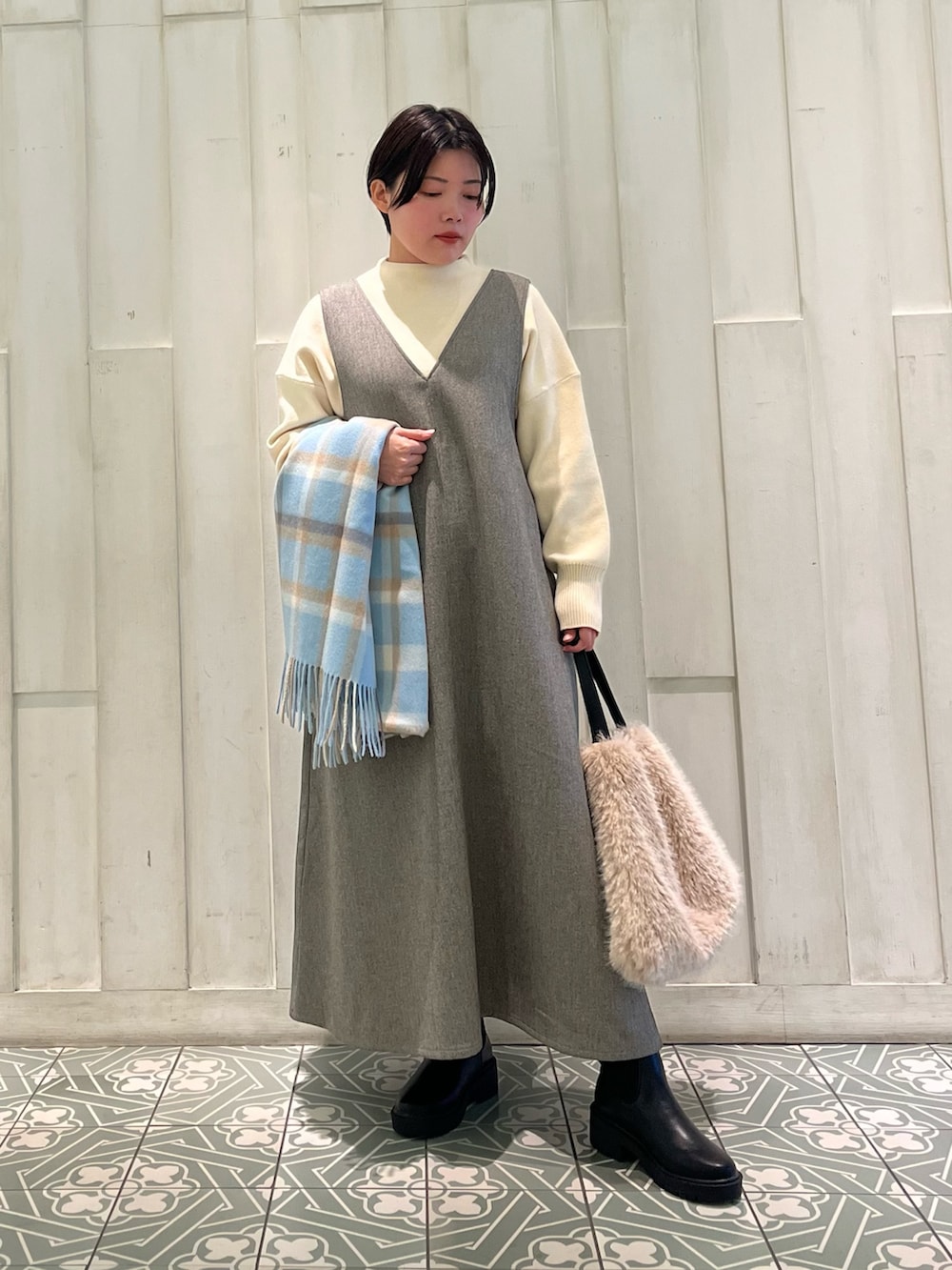 ブルー系のその他アウター、ホワイト系のニット/セーター、グレー系のワンピースを着用したレディースの冬コーディネートの4枚目の写真