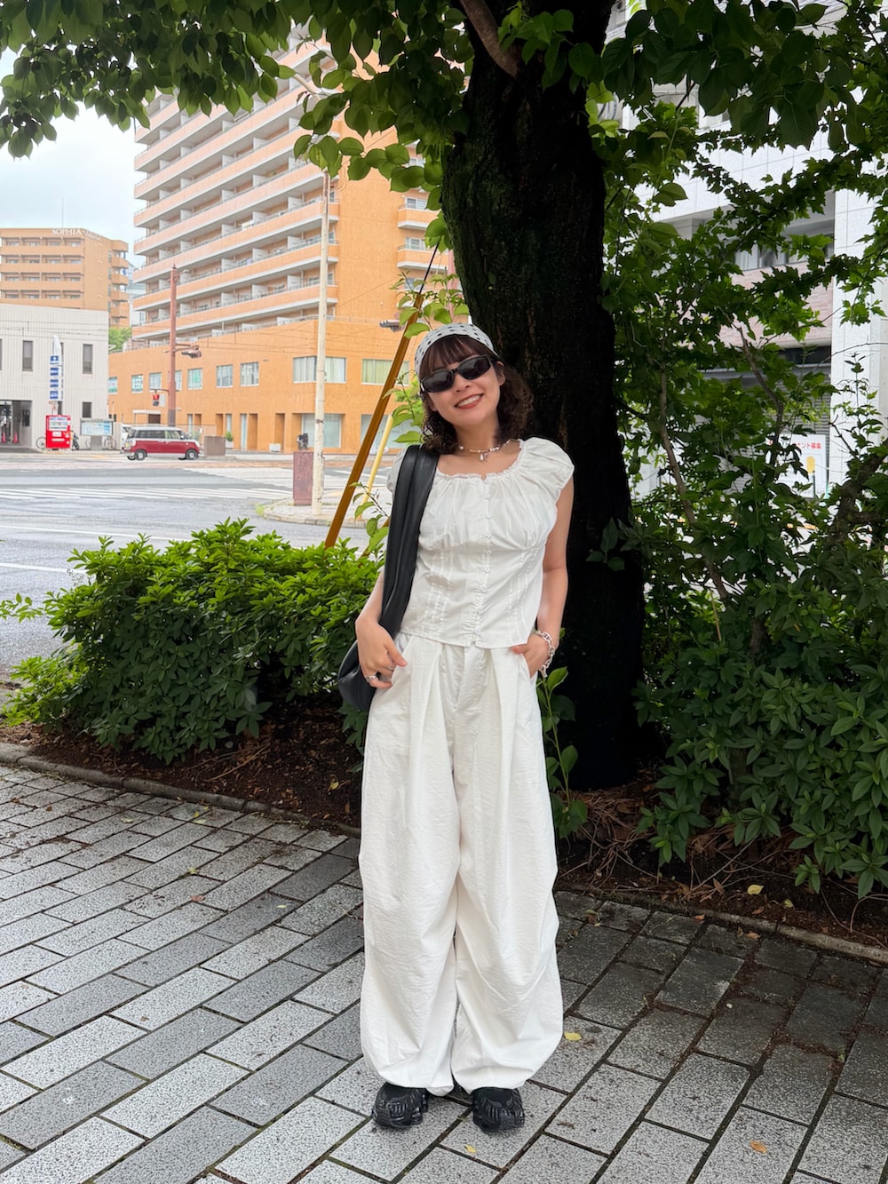 ホワイト系のトップス、ホワイト系のパンツ、ブラック系のスニーカーを着用したレディースの春コーディネートの2枚目の写真