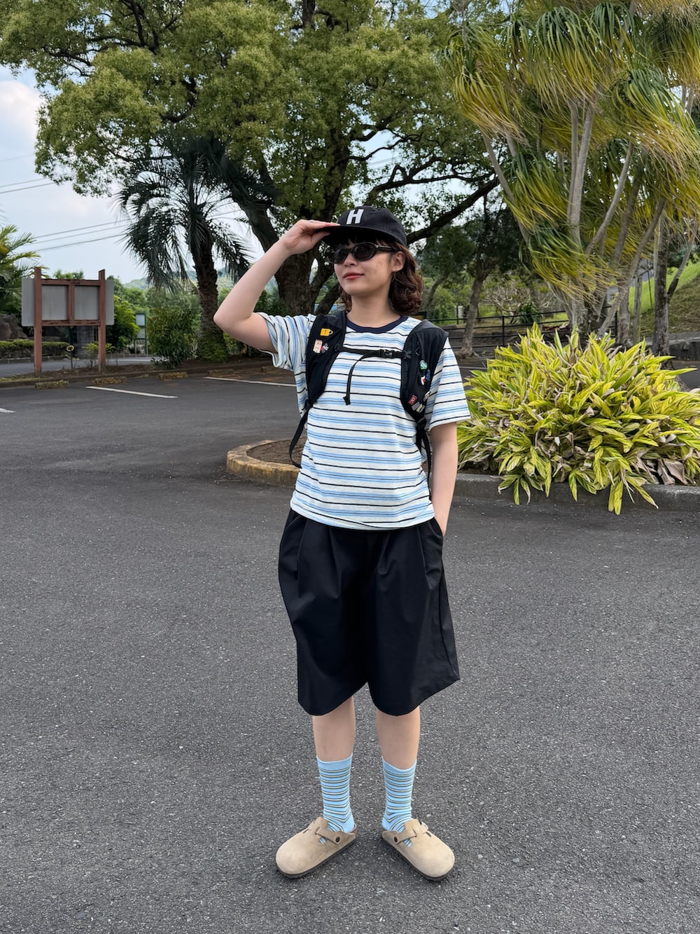 ブルー系のTシャツ/カットソー、ブラック系のバックパック/リュック、ベージュ系のサンダルを着用したレディースの春コーディネートの2枚目の写真