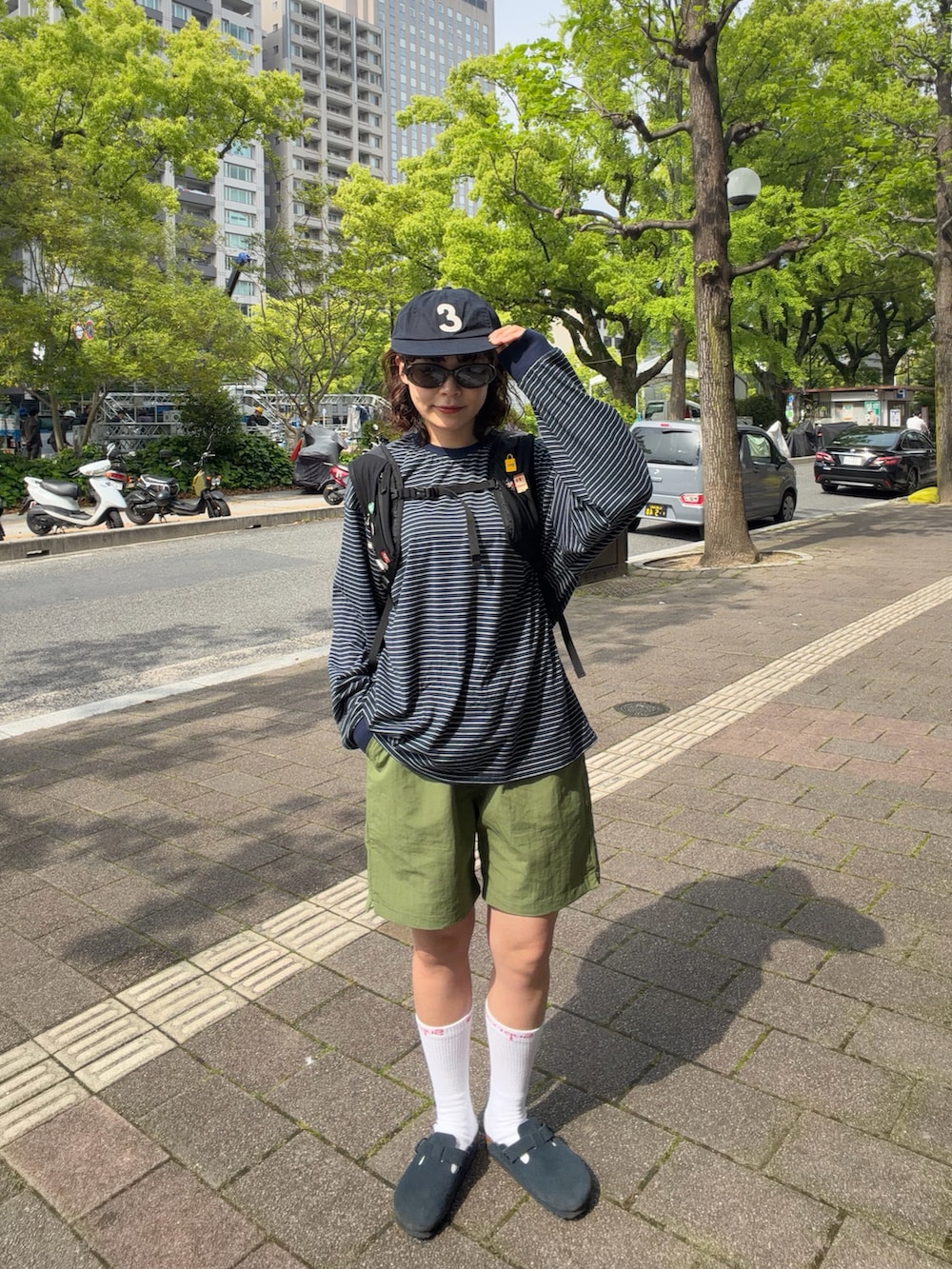 ブラック系のバックパック/リュック、ブルー系のサンダル、ブルー系のTシャツ/カットソーを着用したレディースの春コーディネートの2枚目の写真