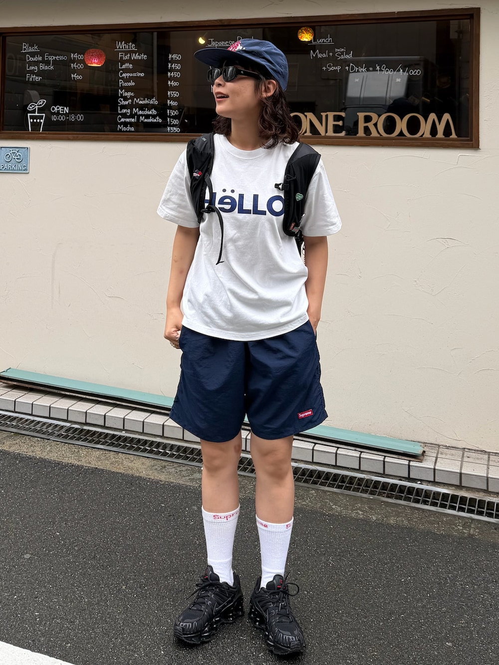 ブラック系のスニーカー、ブラック系のバックパック/リュック、ホワイト系のTシャツ/カットソーを着用したレディースの夏コーディネートの3枚目の写真