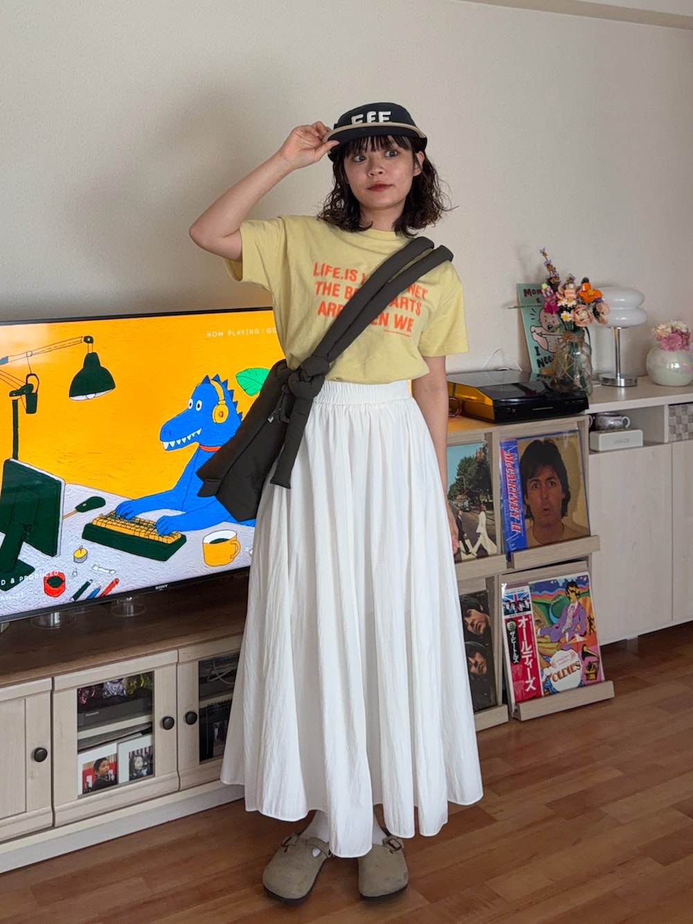 イエロー系のTシャツ/カットソー、グリーン系のハンドバッグ、ベージュ系のサンダルを着用したレディースの夏コーディネートの2枚目の写真