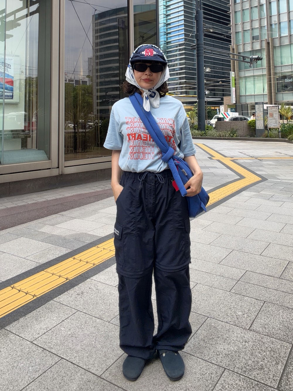 ブルー系のTシャツ/カットソー、ブルー系のハンドバッグ、ブルー系のサンダルを着用したレディースの春コーディネートの2枚目の写真